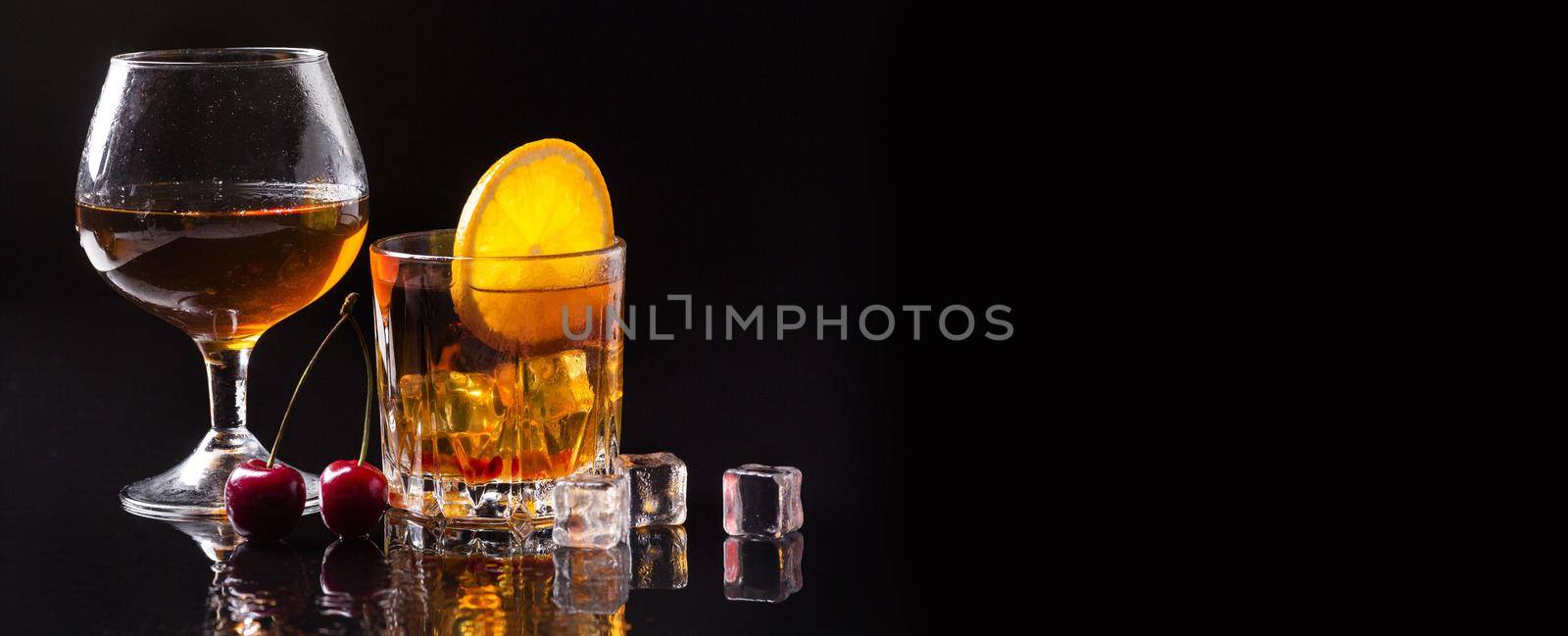 front view whiskey with orange cognac glass with copy space