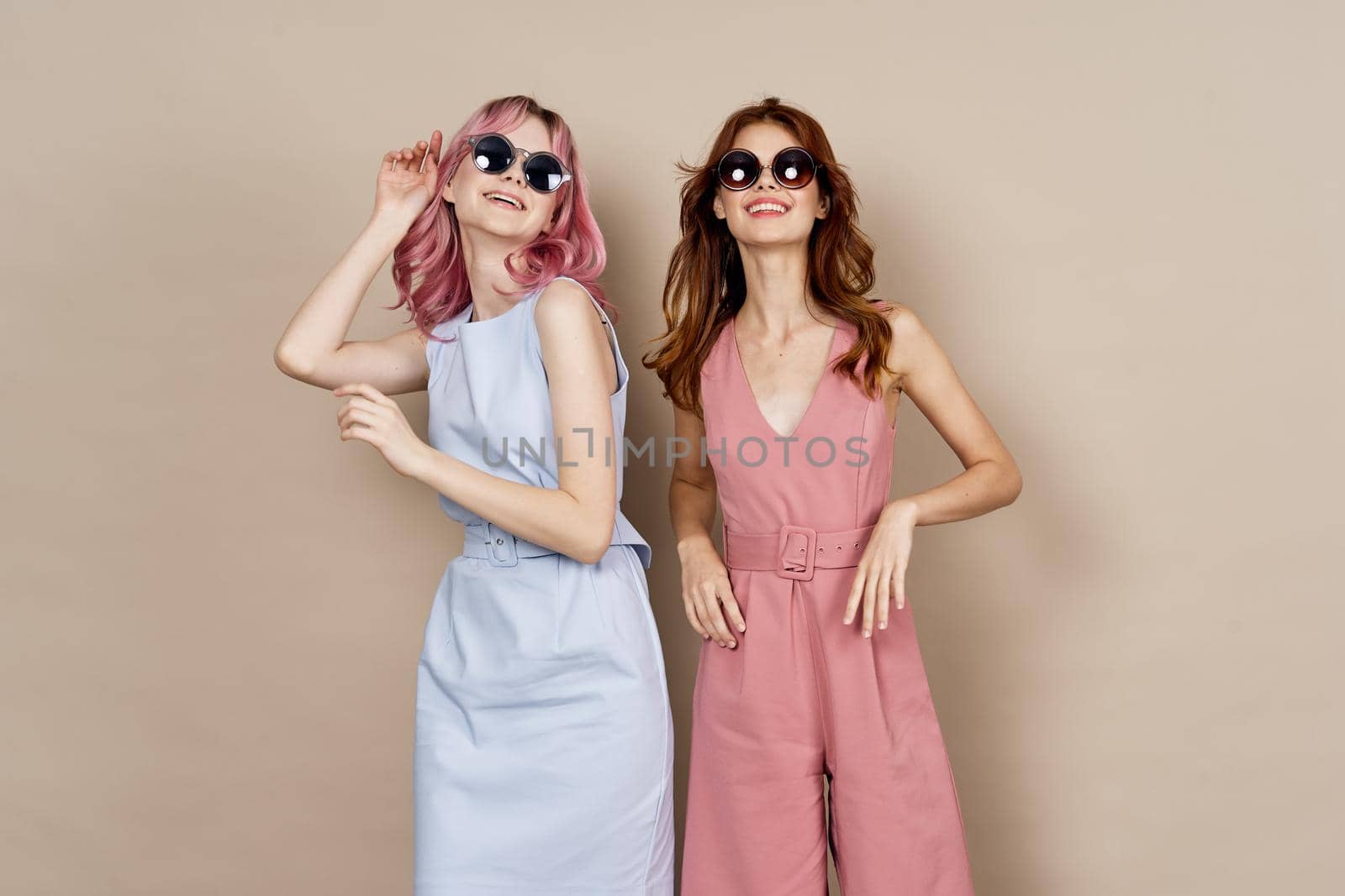 two girlfriends stand side by side fashion clothing glamor posing. High quality photo
