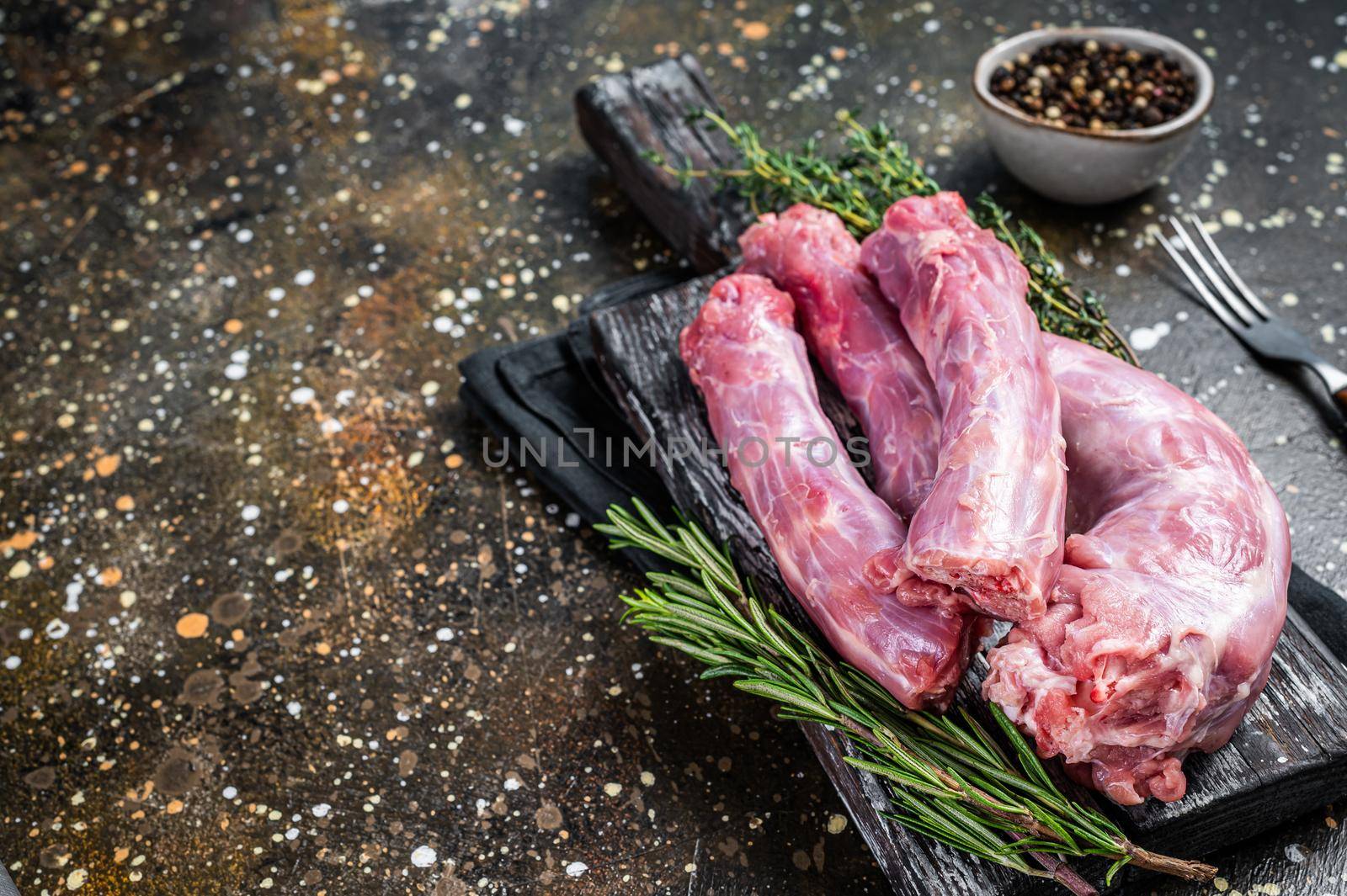 Raw Turkey or chicken necks meat on a wooden board with thyme. Brown background. Top View. Copy space.