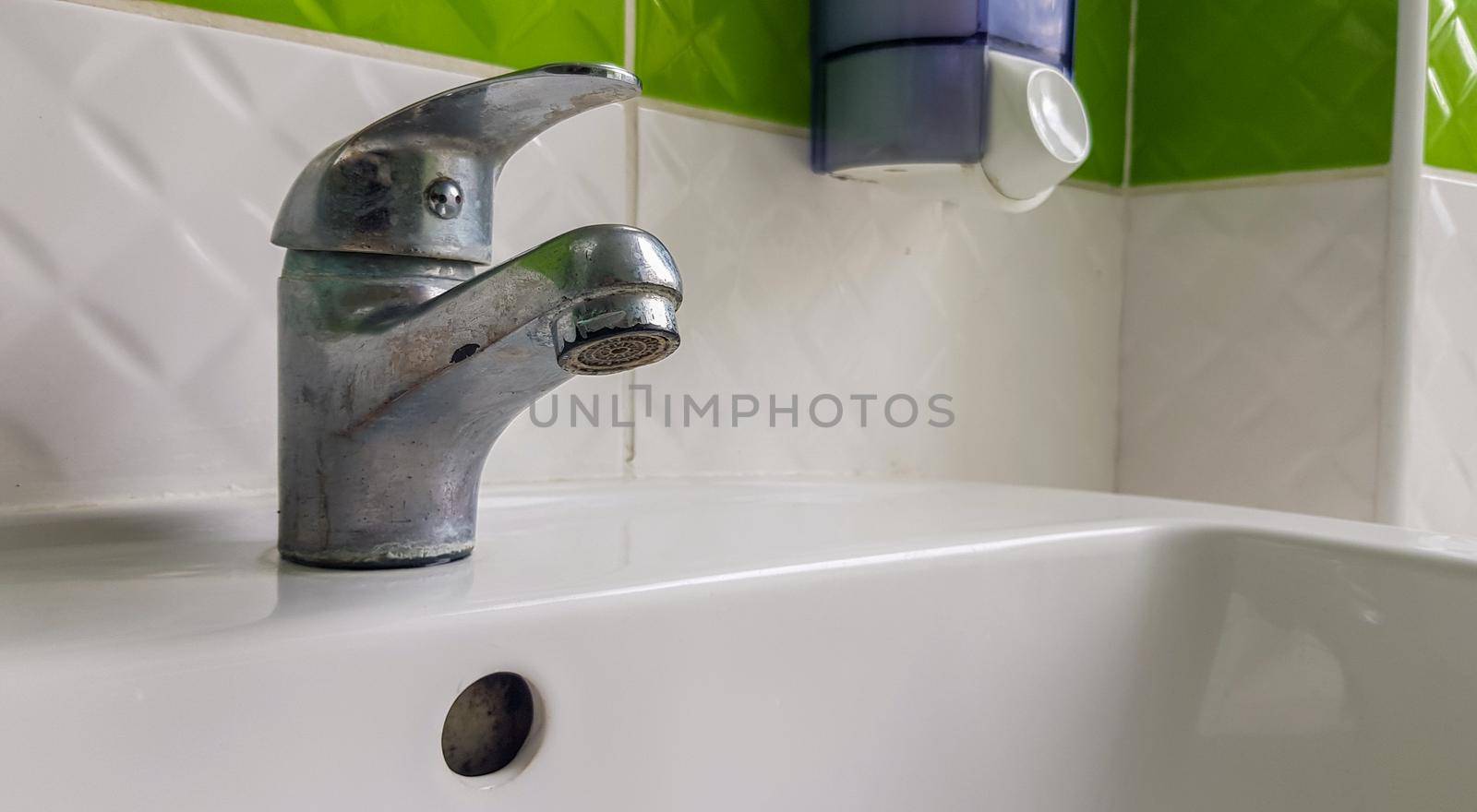 Old aluminum sink mixer. Water tap in the toilet for clean hands