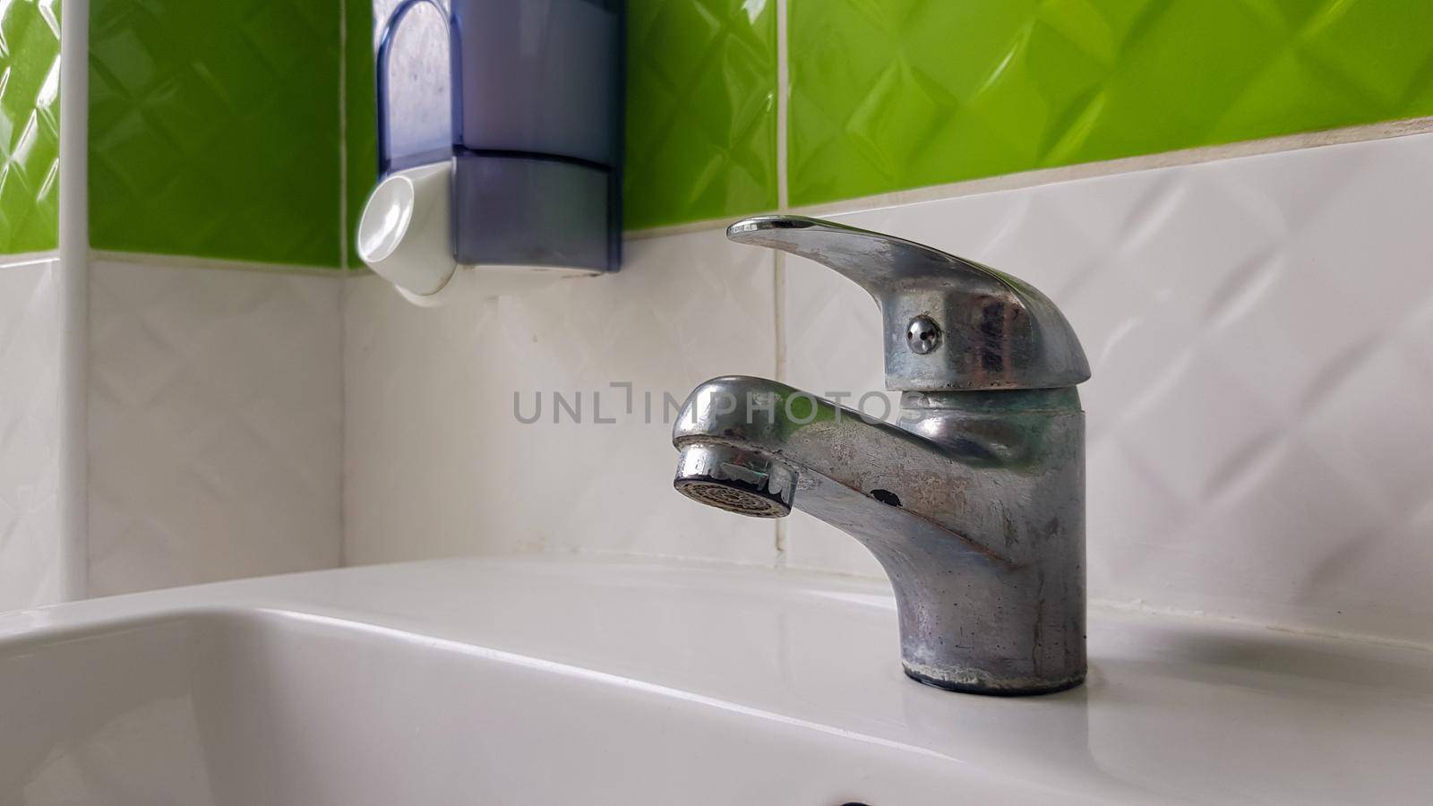 Old aluminum sink mixer. Water tap in the toilet for clean hands
