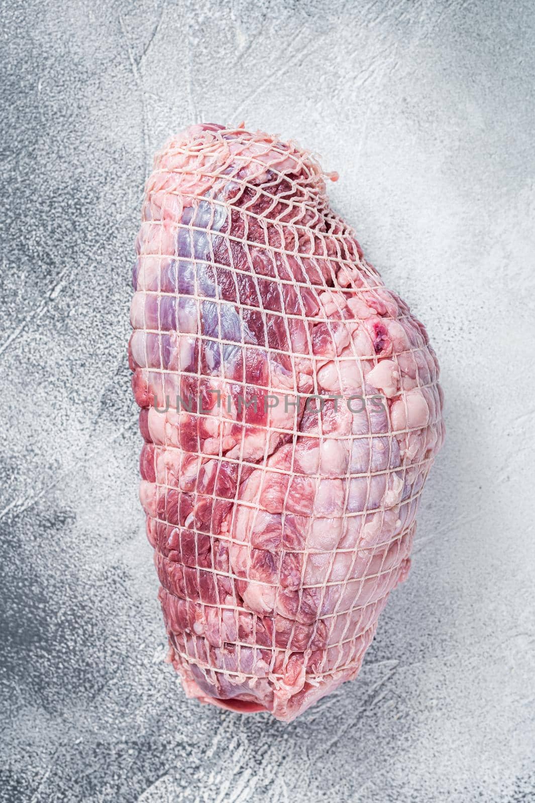Boneless Leg of Lamb meat on butcher table. White background. Top view by Composter