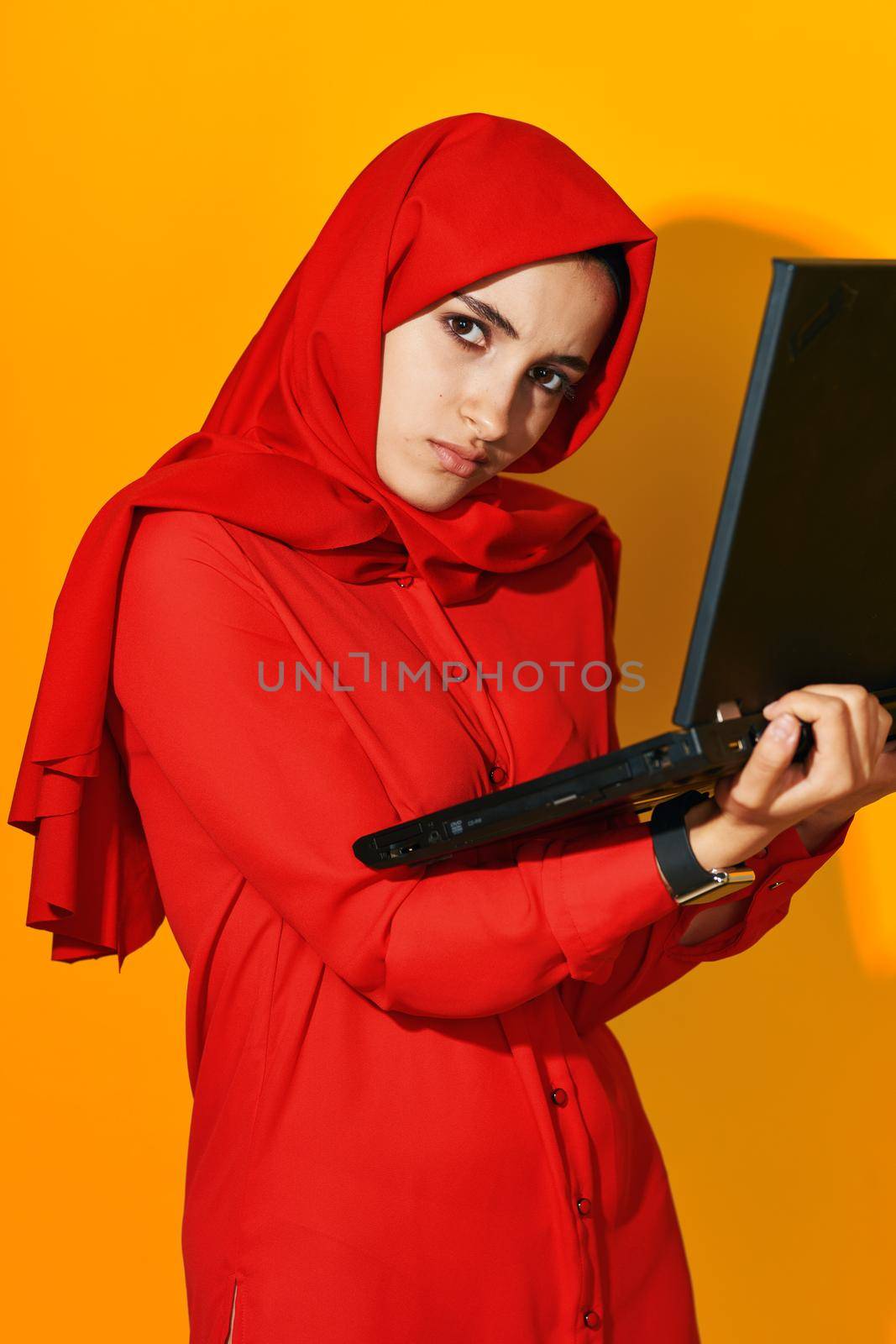 arab woman laptop posing technology internet yellow background. High quality photo
