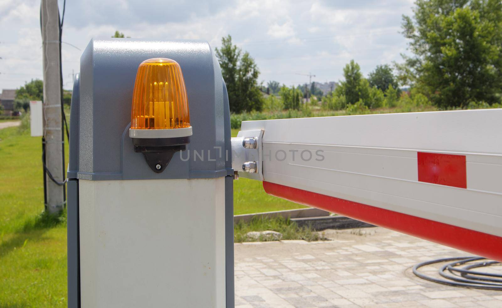 Close the gate. Automatic security system. Automatic entry system. Yellow light signal with a street barrier. Barrier gates Automatic security system