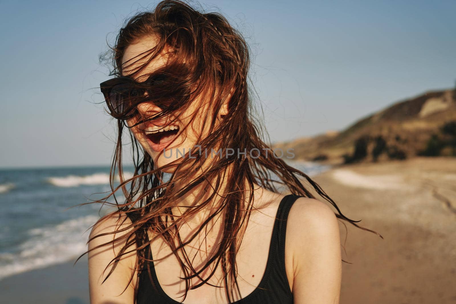 cheerful woman in sunglasses in a swimsuit on the beach sun island. High quality photo
