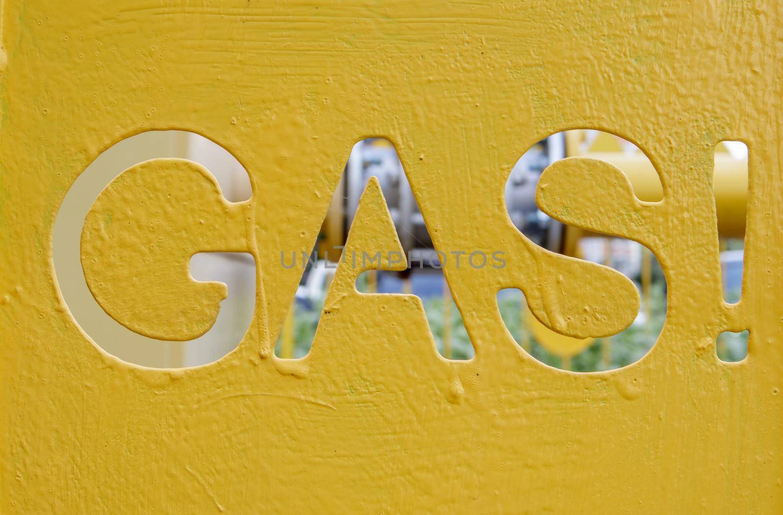 Warning on a metal cage with gas equipment for the public. Attention gas pipe. The inscription in English GAZ. A yellow warning sign for a medium pressure gas pipeline on a surface installation