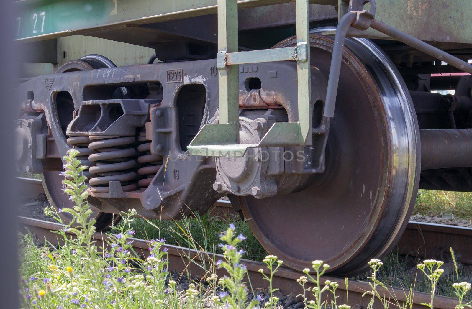 The undercarriage of the carriage with wheels and springs. Passenger train, freight train. Industrial railway wheels close up