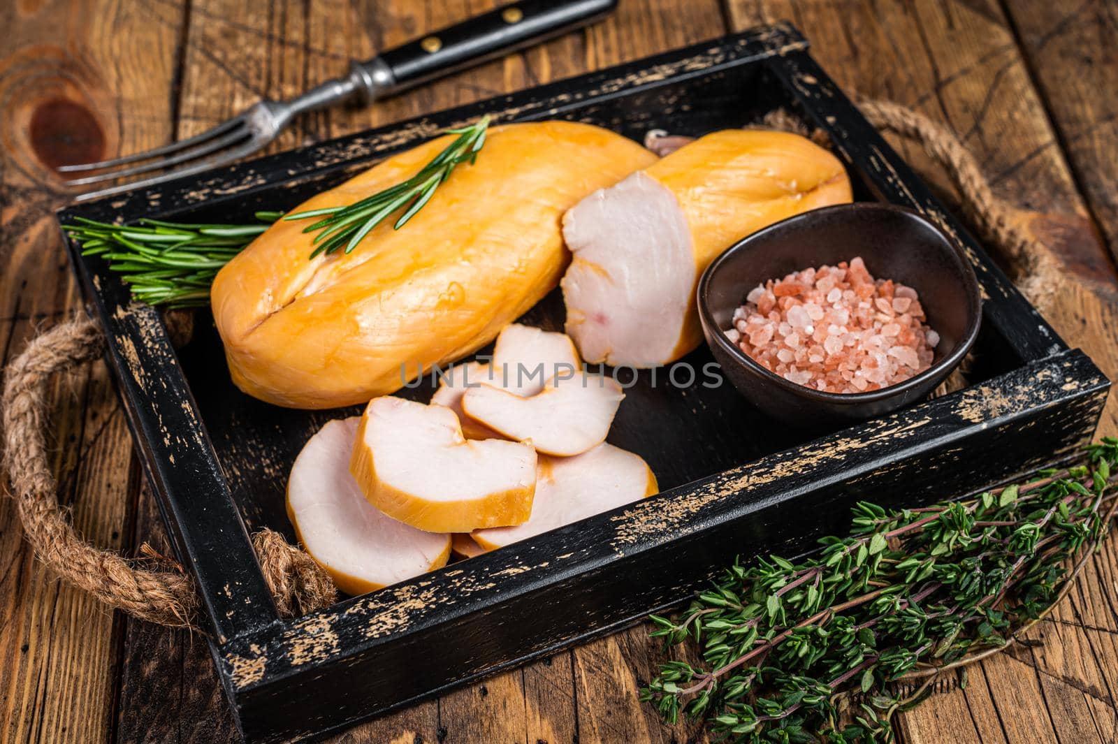 Hot Smoked chicken breast fillet meat on a wooden board with herbs. wooden background. Top view by Composter