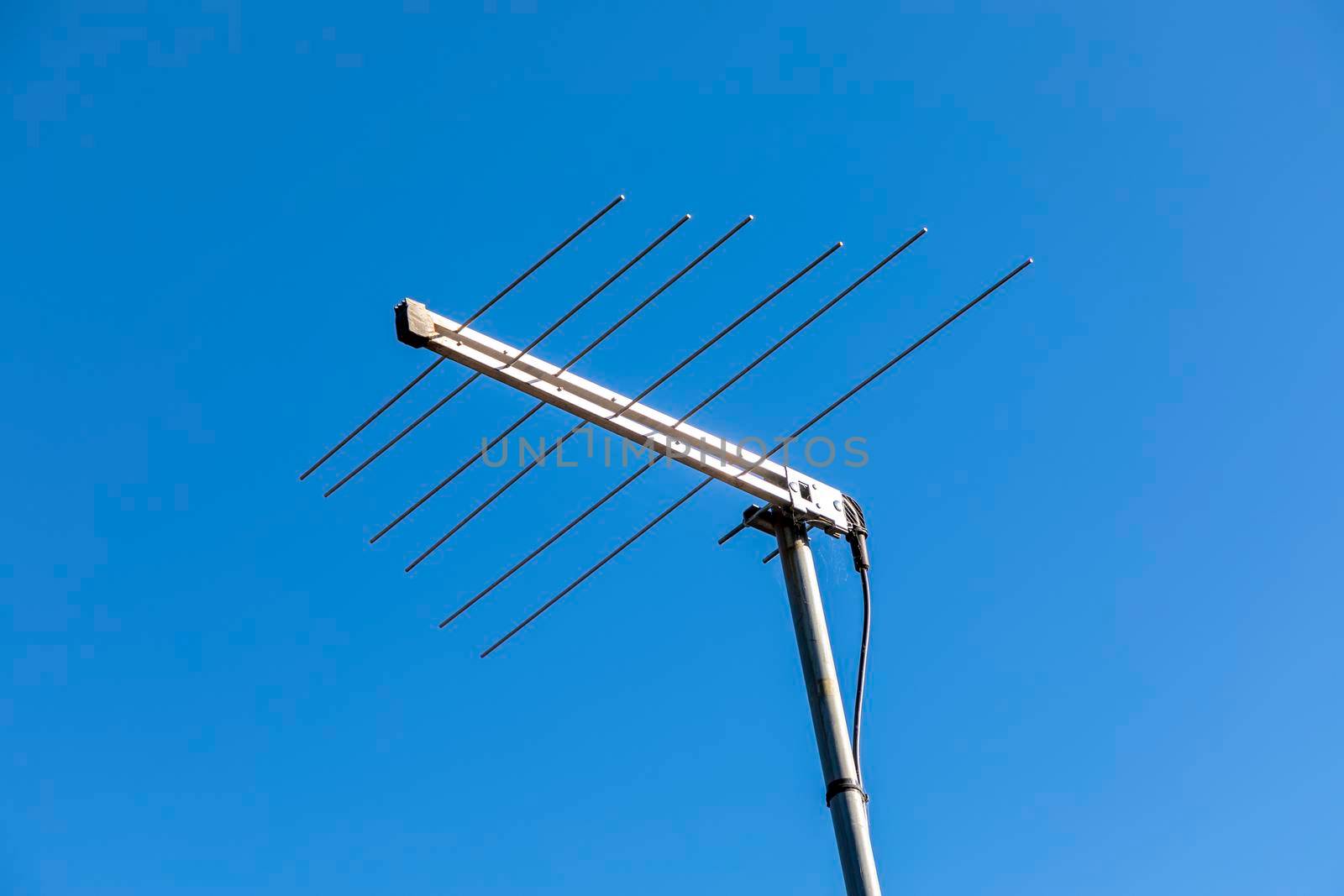 A television antenna against a blue sky background by WittkePhotos