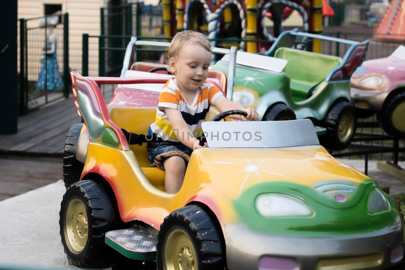 A child rides a car in the amusement park