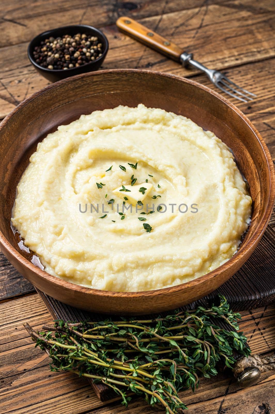 Mashed potatoes, boiled puree in a wooden plate. Wooden background. Top view by Composter