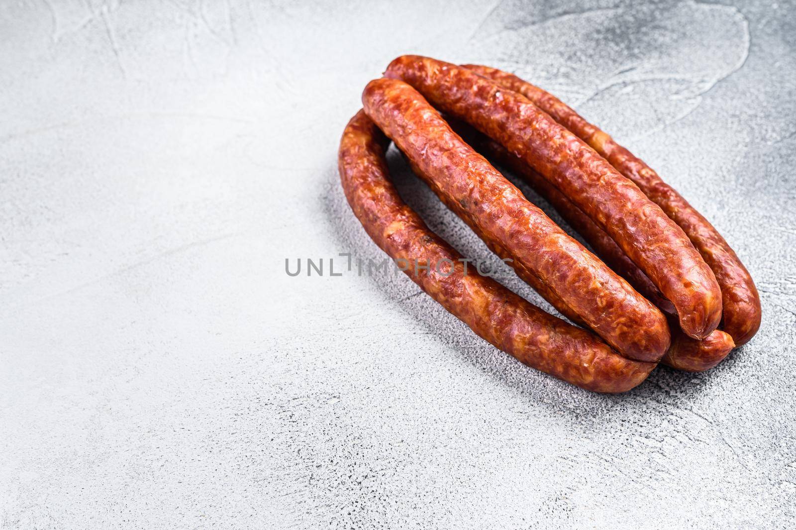 Hot Smoked sausages on a rustic table. White background. Top view. Copy space by Composter