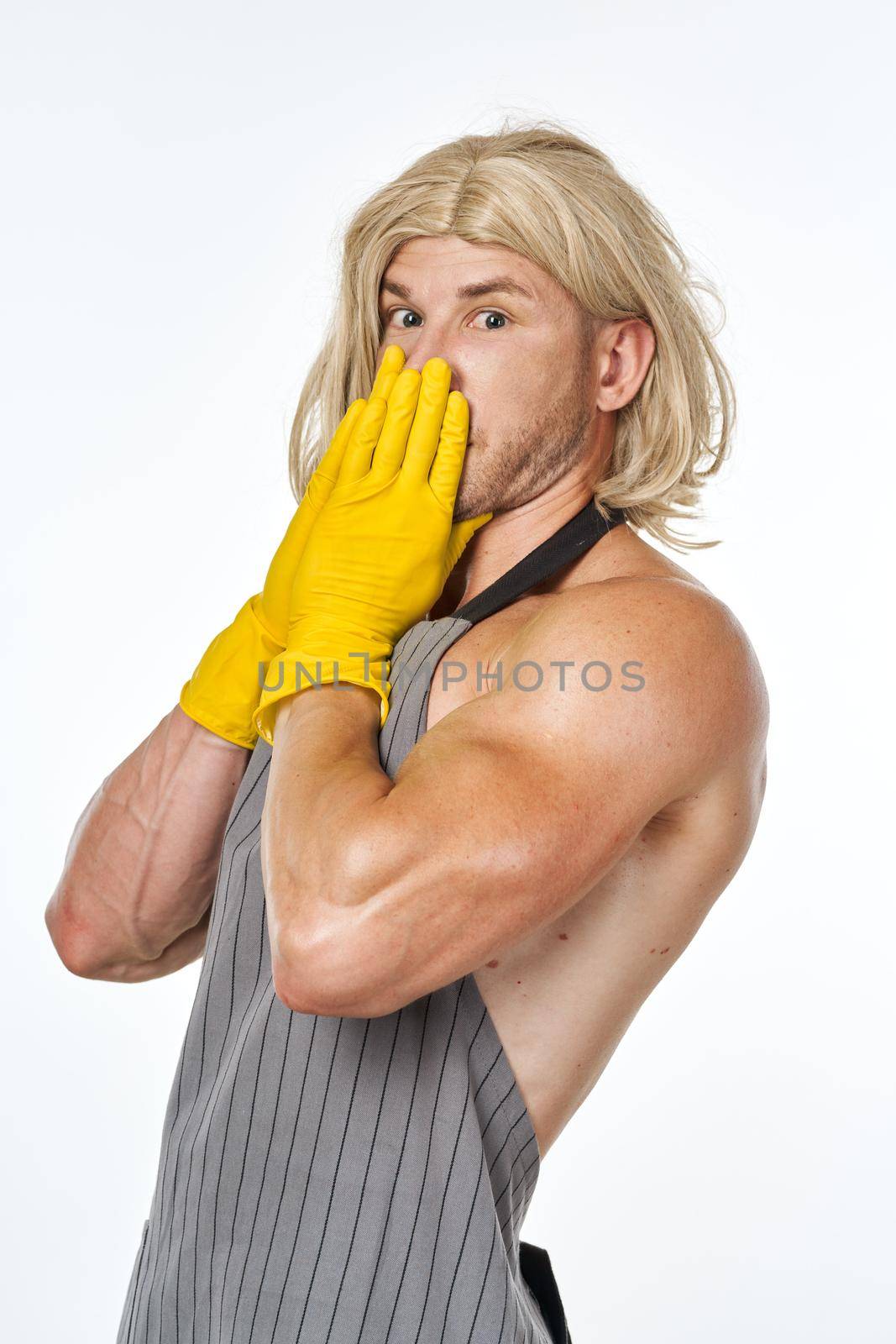 man in yellow rubber gloves in a woman's wig cleaning posing. High quality photo