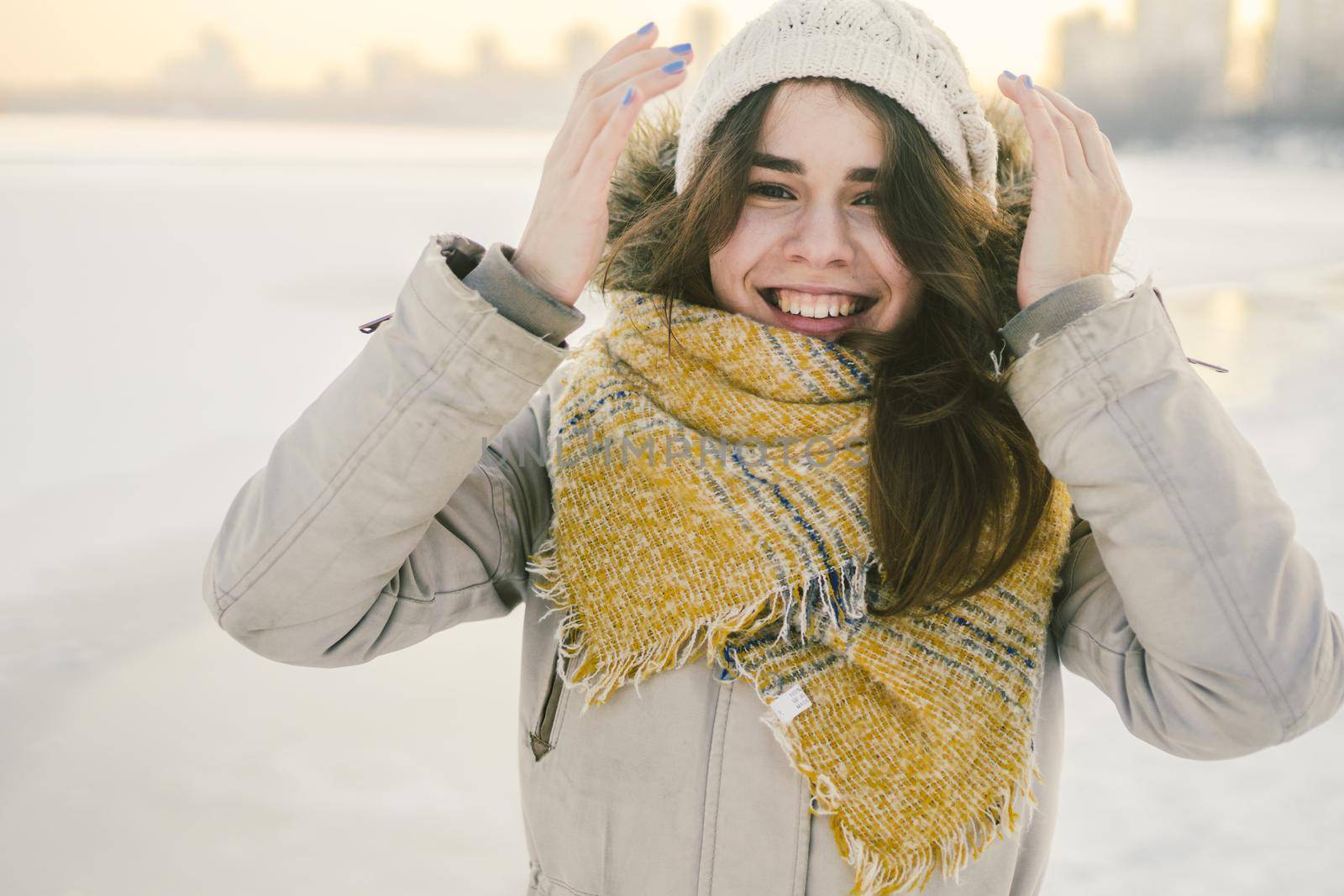 Beautiful happy laughing young woman wearing winter hat and scarf. winter background with snow. Winter holidays concept. Happy Woman In Winter Nature.