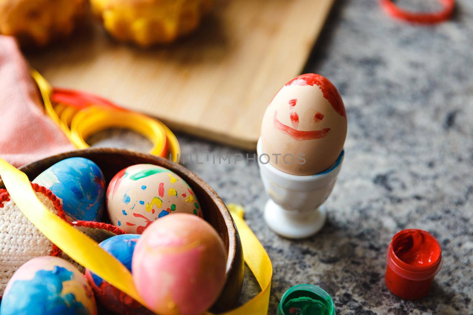 Kid Easter preparation by painting Easter eggs and holiday decorations at home close up