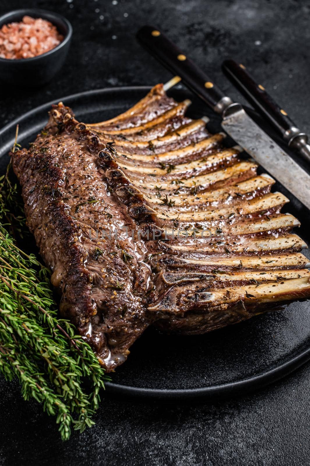 BBQ Grilled rack of Lamb mutton Ribs Chops on plate with thyme. Black background. Top view by Composter