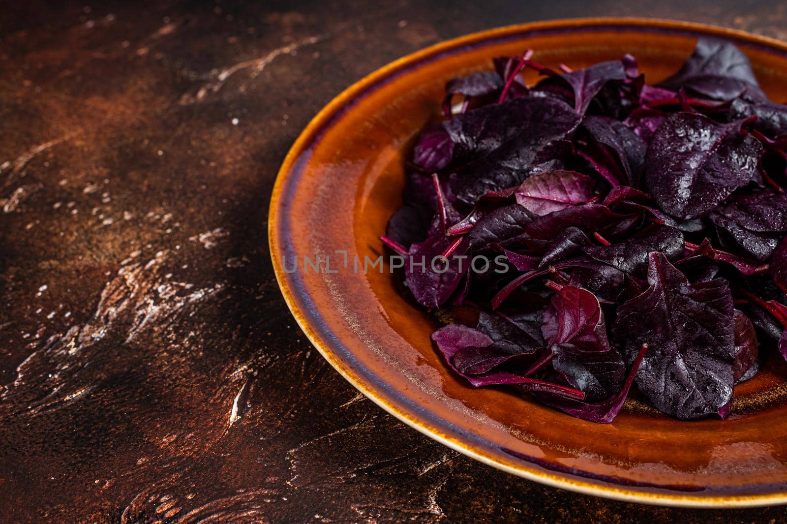 Raw Ruby or red chard salad Leafs on a rustic plate. Dark background. Top view. Copy space.