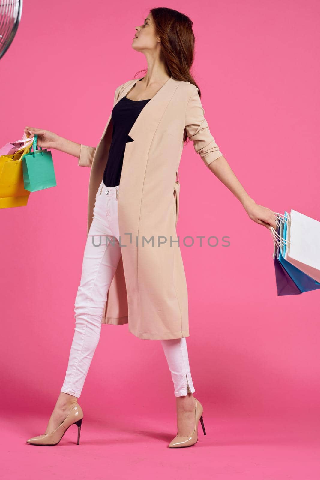 cheerful woman with packages in hands Shopaholic pink background. High quality photo