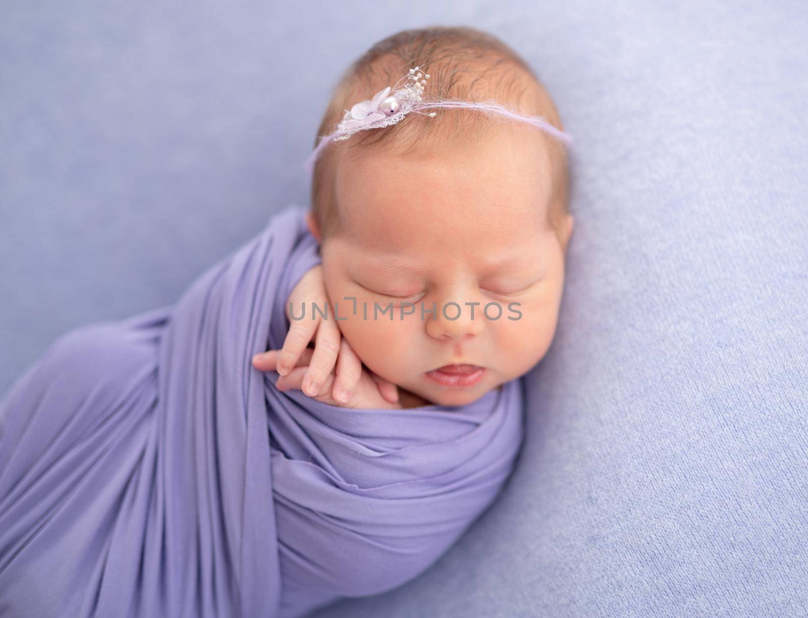 Adorable newborn baby sleeping wrapped up