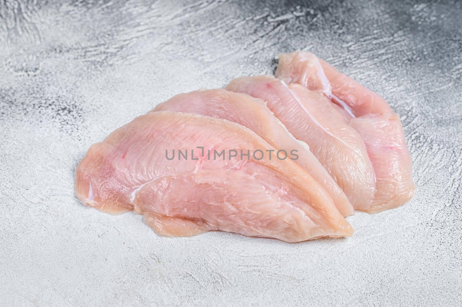 Raw sliced chicken breast fillet steaks. White background. Top view.