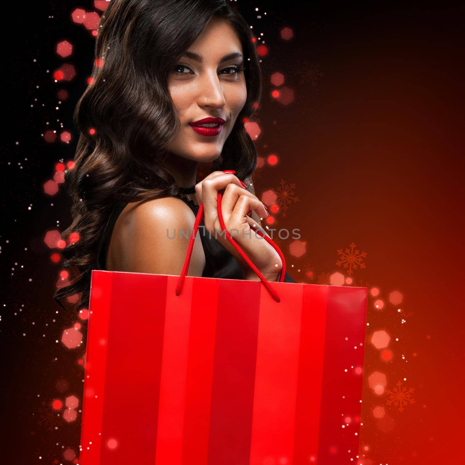 Beautiful young woman make shopping in black friday holiday. Girl with black bag on dark background.