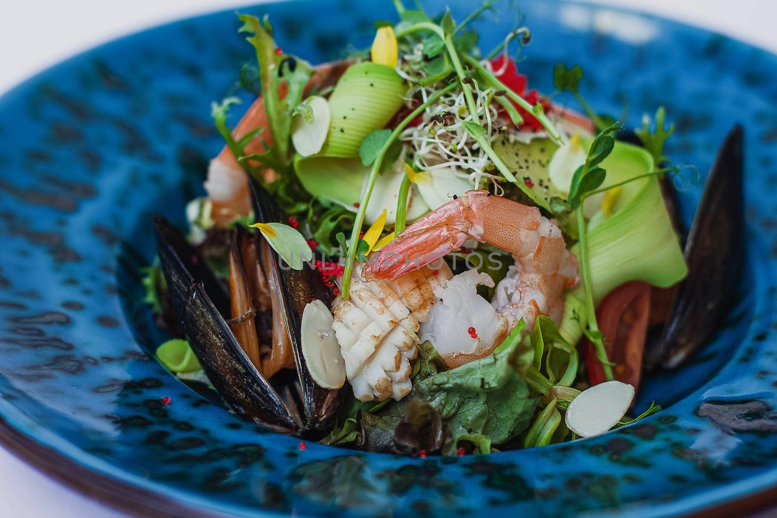 Seafood salad, with mixed greens, avocado, shrimps, mussels. Delicious healthy eating.