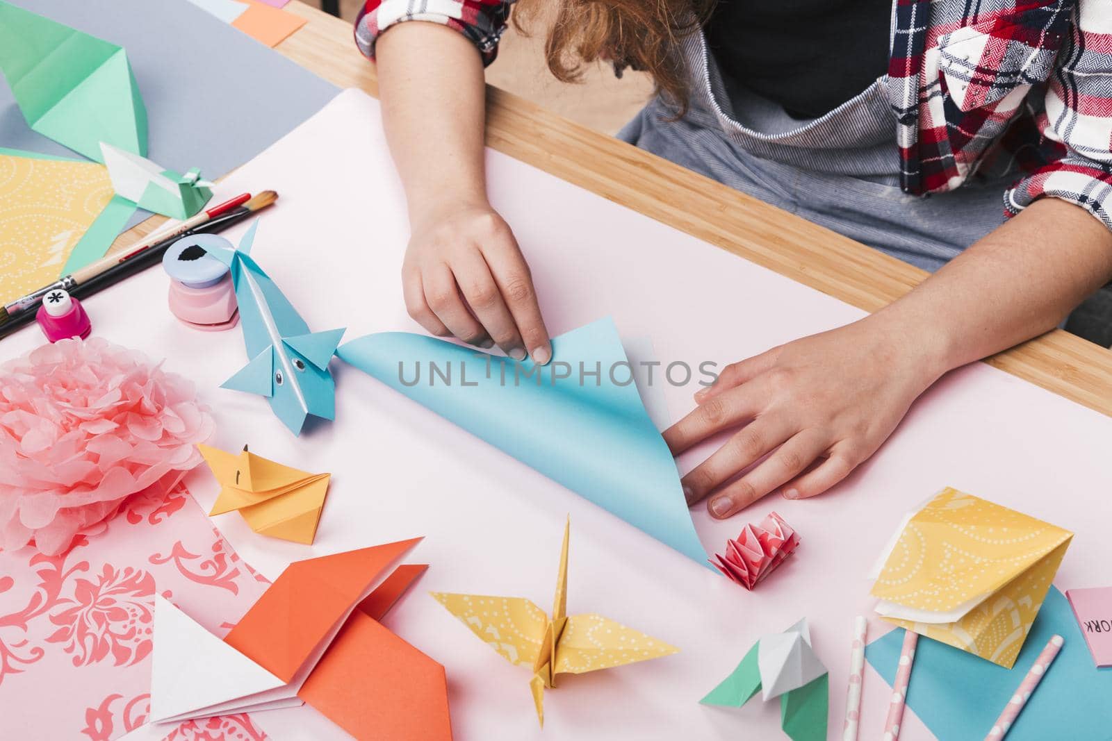 female artist folding origami paper making beautiful craft