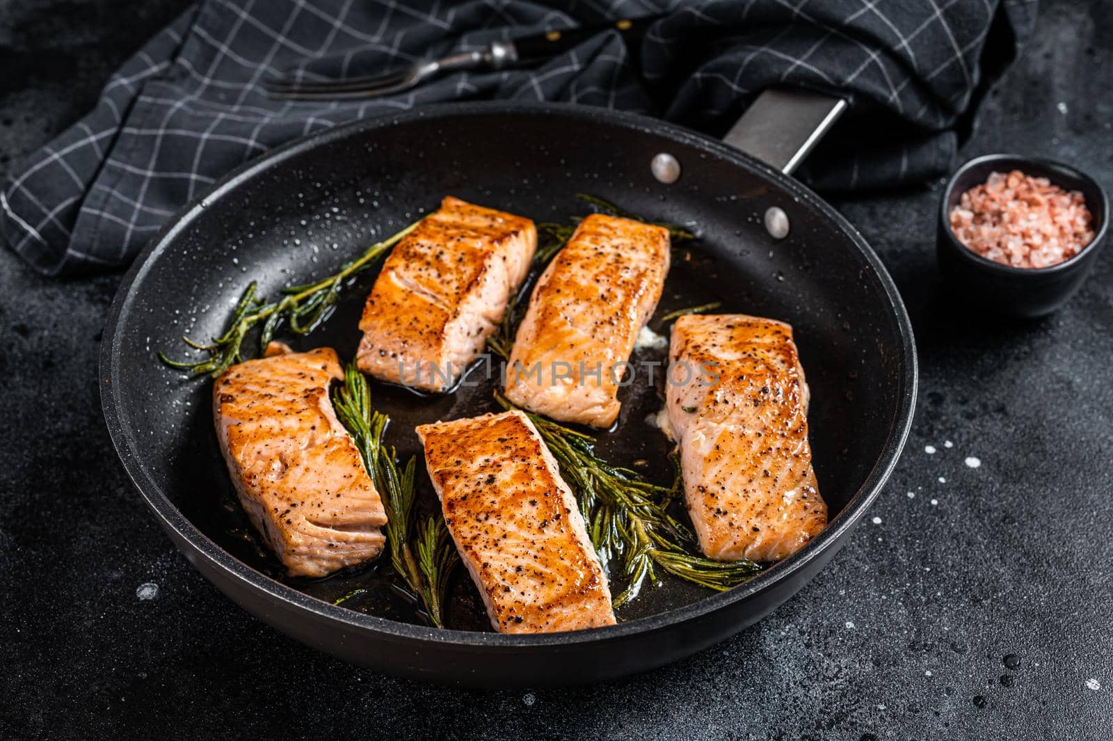 Grilled Salmon Fillet Steak in a pan. Black background. Top view.