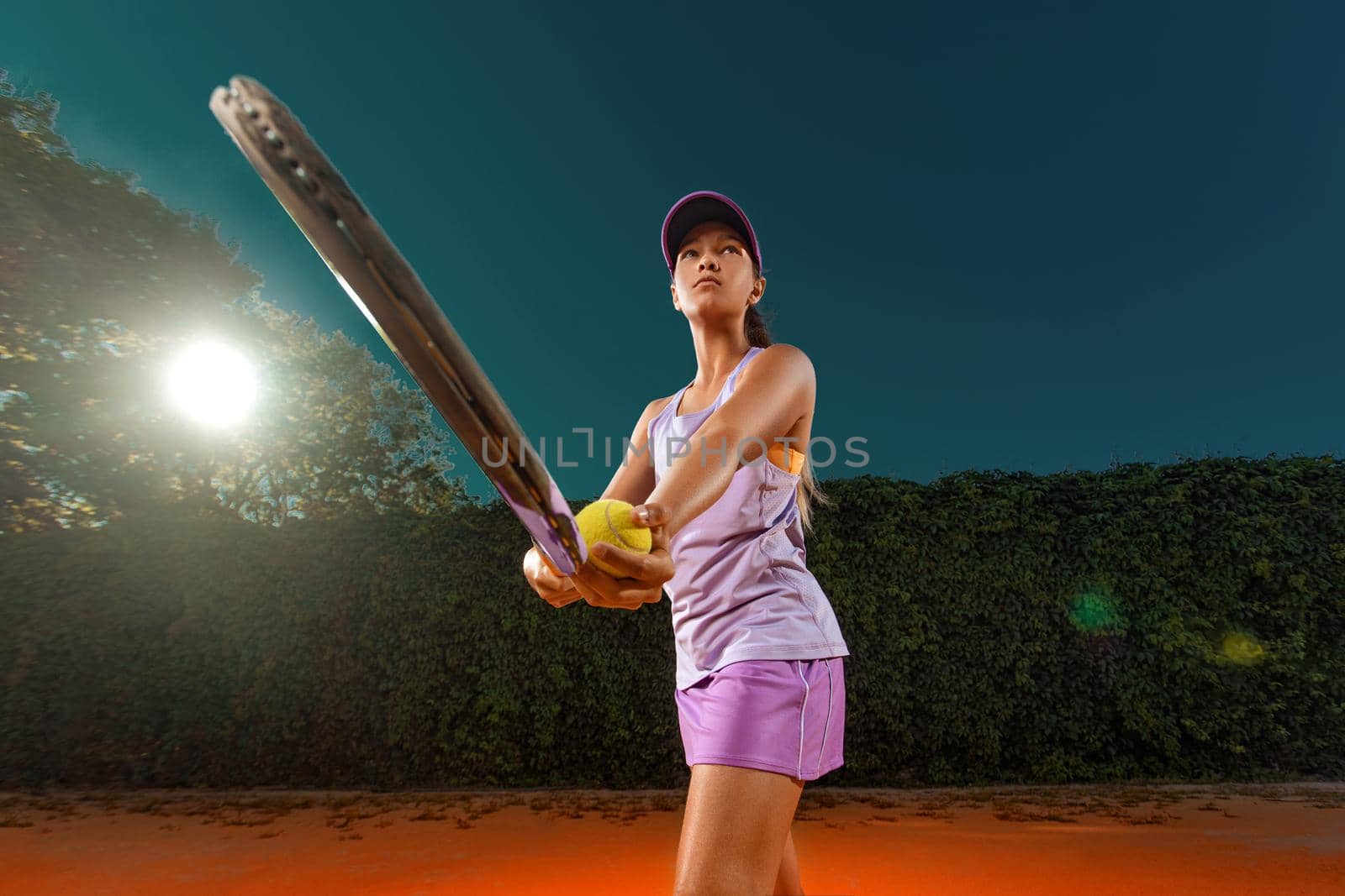 Tennis player. Beautiful girl teenager and athlete with racket in pink sporswear and hat on tennis court. Fashion and sport concept. by MikeOrlov