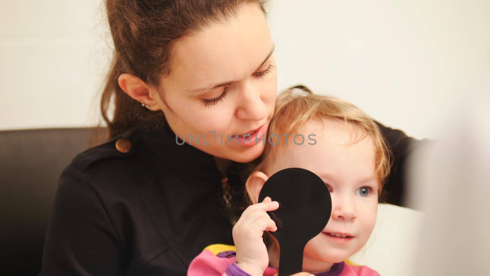 Optometrist concept - mother and child in ophthalmologist room, horizontal