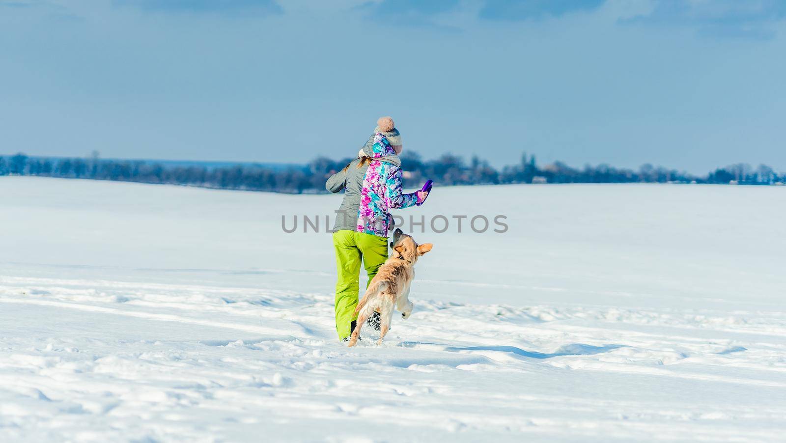 Girl running in snow with dog by tan4ikk1