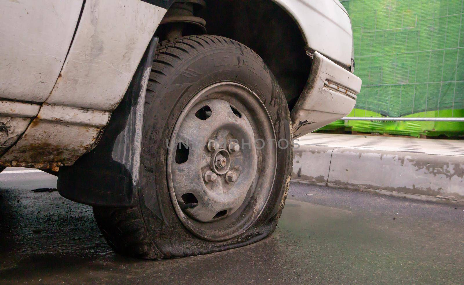 Abandoned old broken car with flat wheels. A tire with a flat tire. The concept of accident, breakdown, repair, insurance. A flat tire on a car wheel. Ukraine, Kiev - August 19, 2021