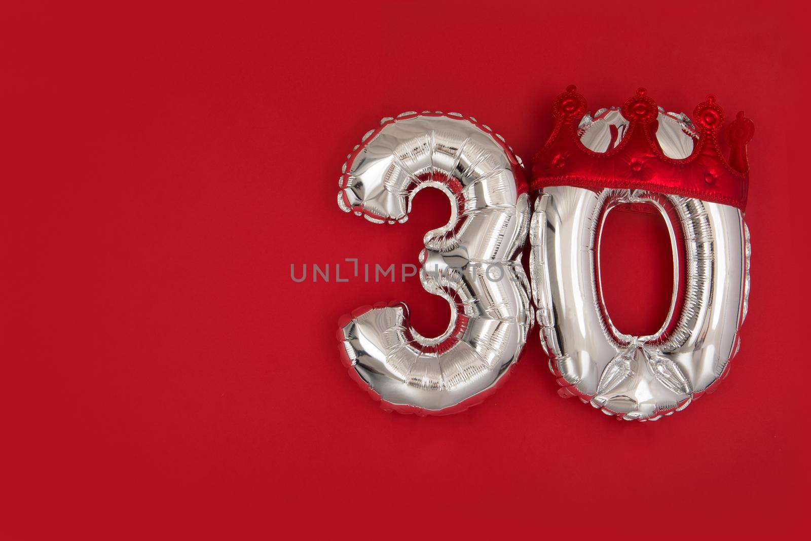 Balloon 30 in crown on dark red background flat lay by Demkat