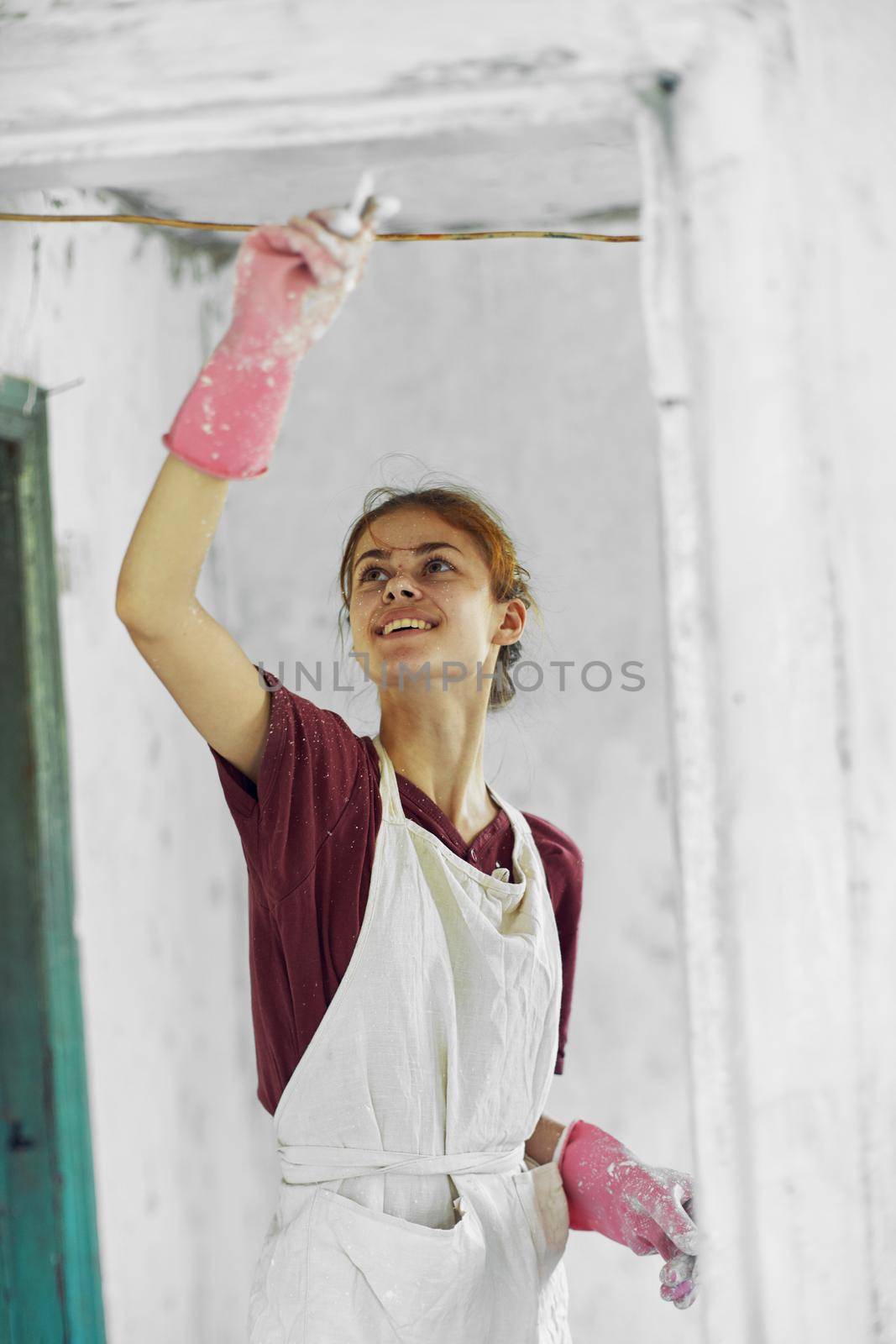 cheerful woman painter In a white apron home renovation. High quality photo