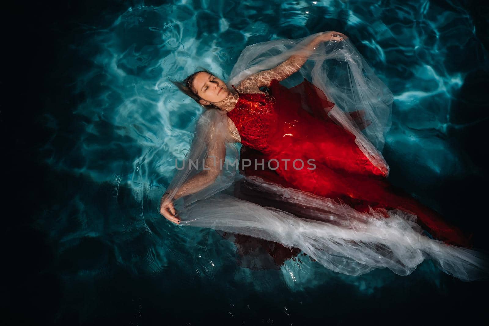 A girl in a red dress is floating on the water.A journey on the water of a single woman by Lobachad