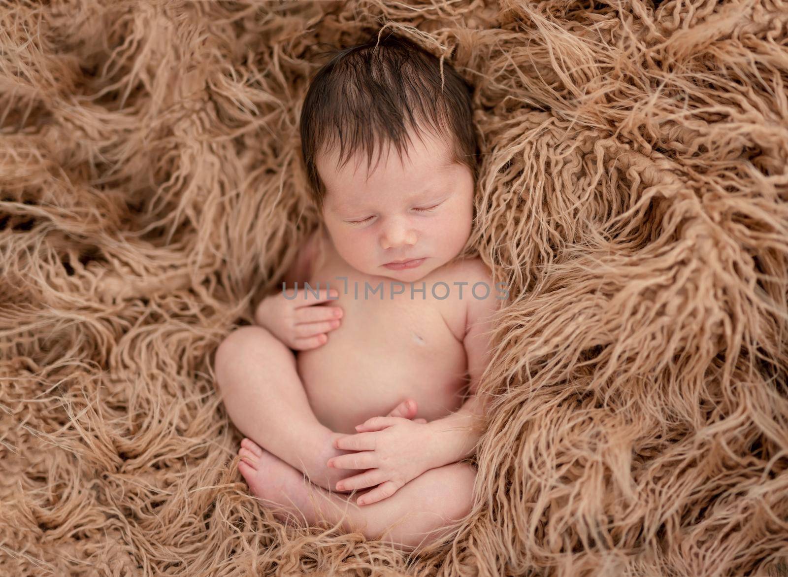 Charming naked newborn calmly sleeping