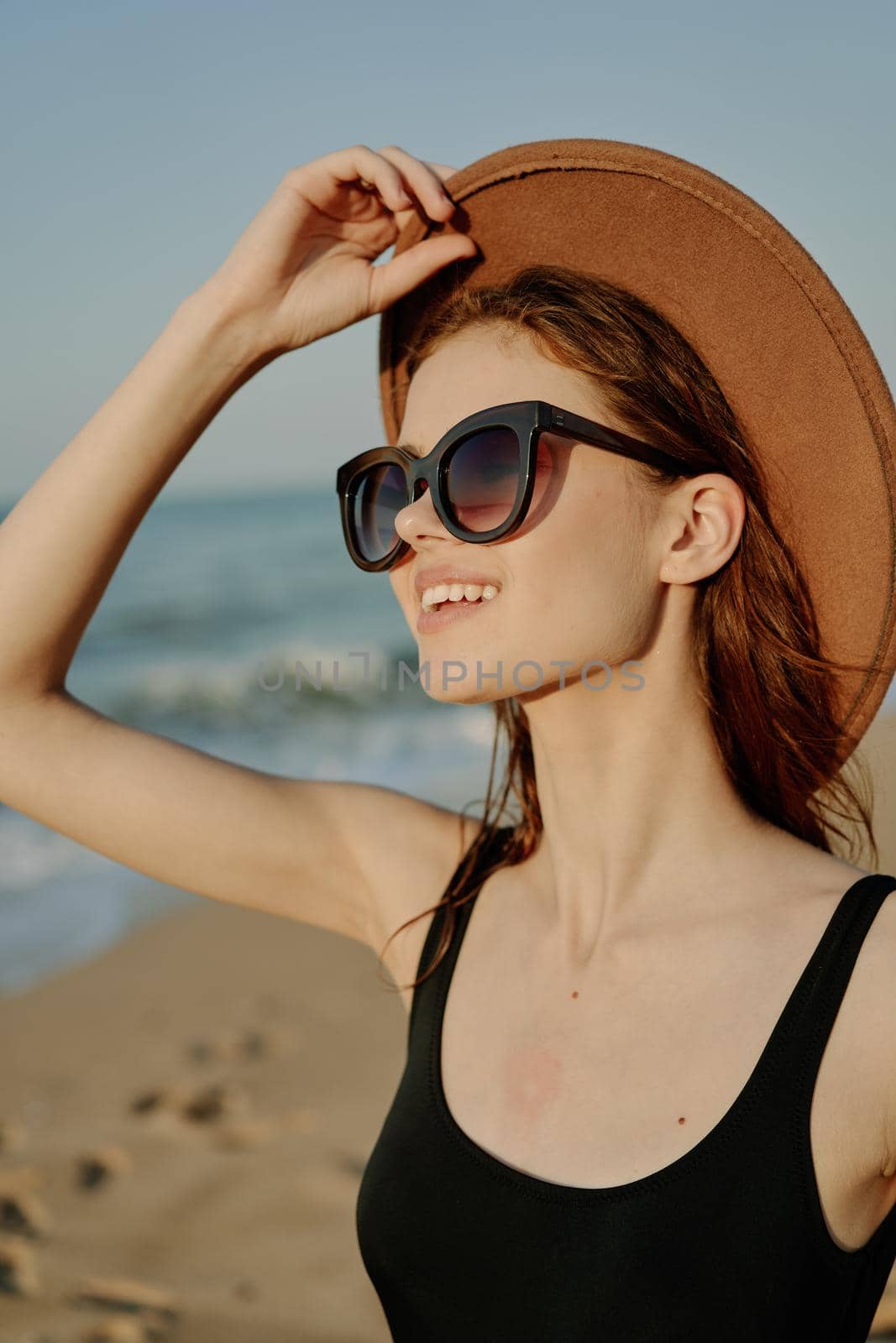 cheerful woman in sunglasses Sandy coast landscape sun. High quality photo