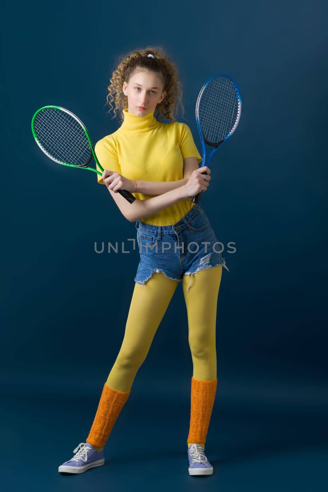 Shot of pretty girl tennis player holding rackets by kolesnikov_studio