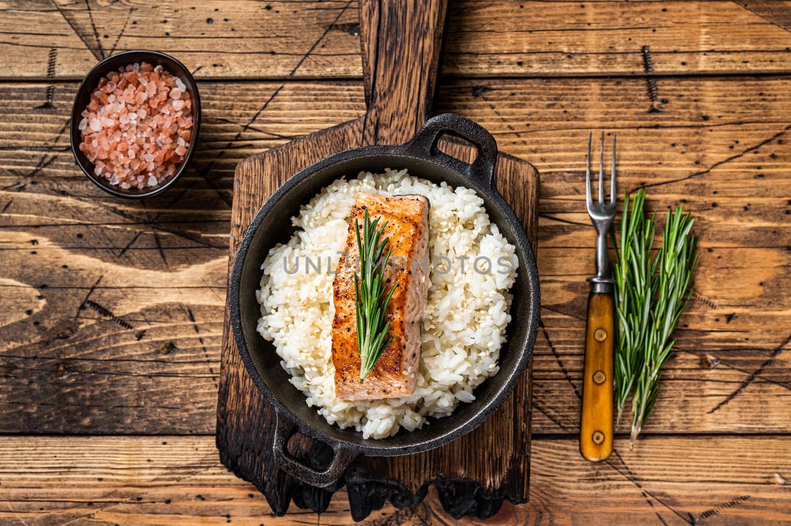 Grilled Salmon Fillet Steaks with white rice in a pan. wooden background. Top view.