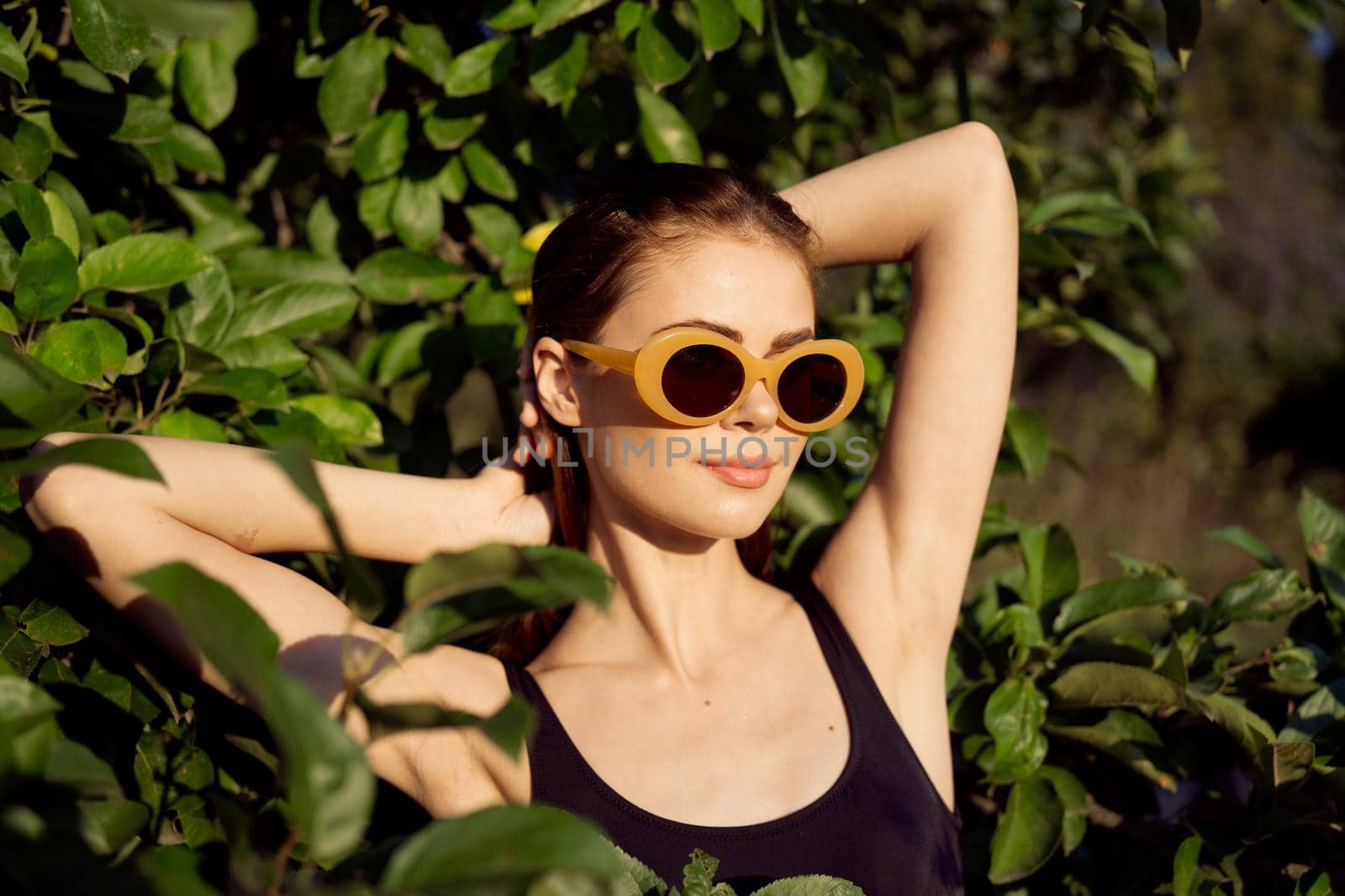 pretty woman in black swimsuit sunglasses green leaves nature by Vichizh