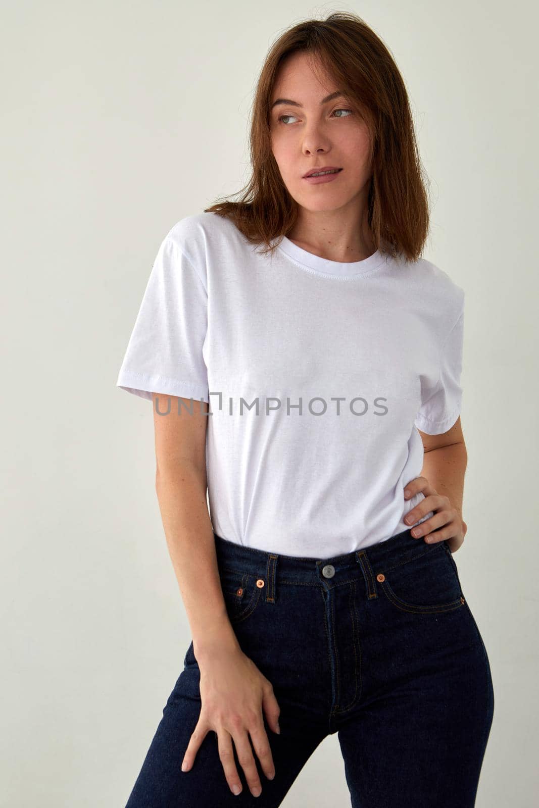 Cute woman in casual outfit standing in studio by Demkat