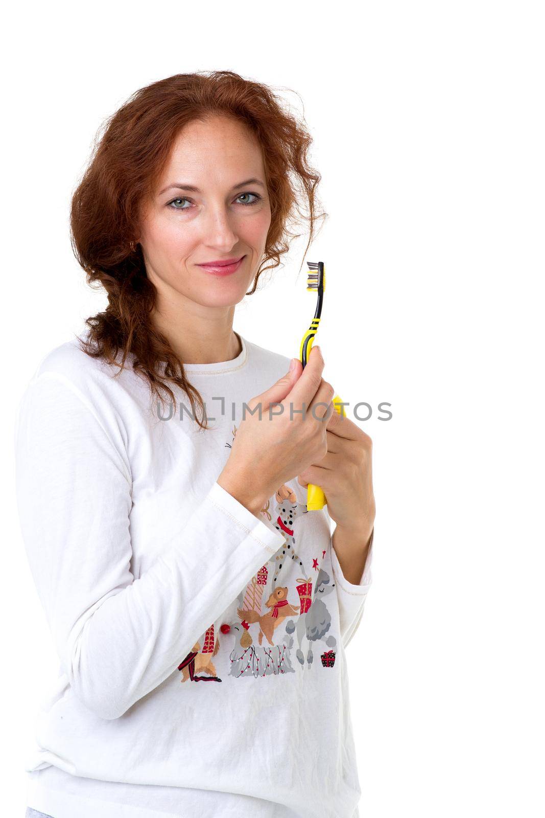 Young woman holding tooth brush and toothpaste. Portrait of smiling woman wearing casual clothes standing against white background. Healthy lifestyle, daily routine concept