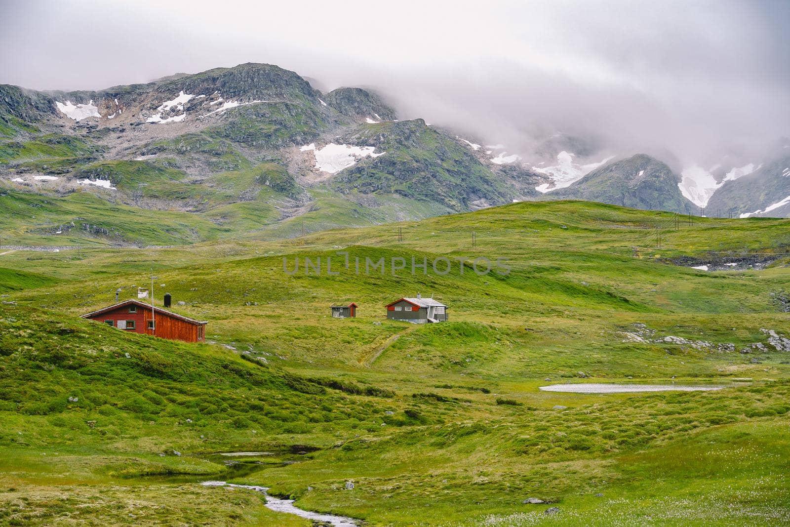 hut wooden mountain huts in mountain pass Norway. Norwegian landscape with typical scandinavian grass roof houses. Mountain village with small houses and wooden cabins with grass on roof in valley.