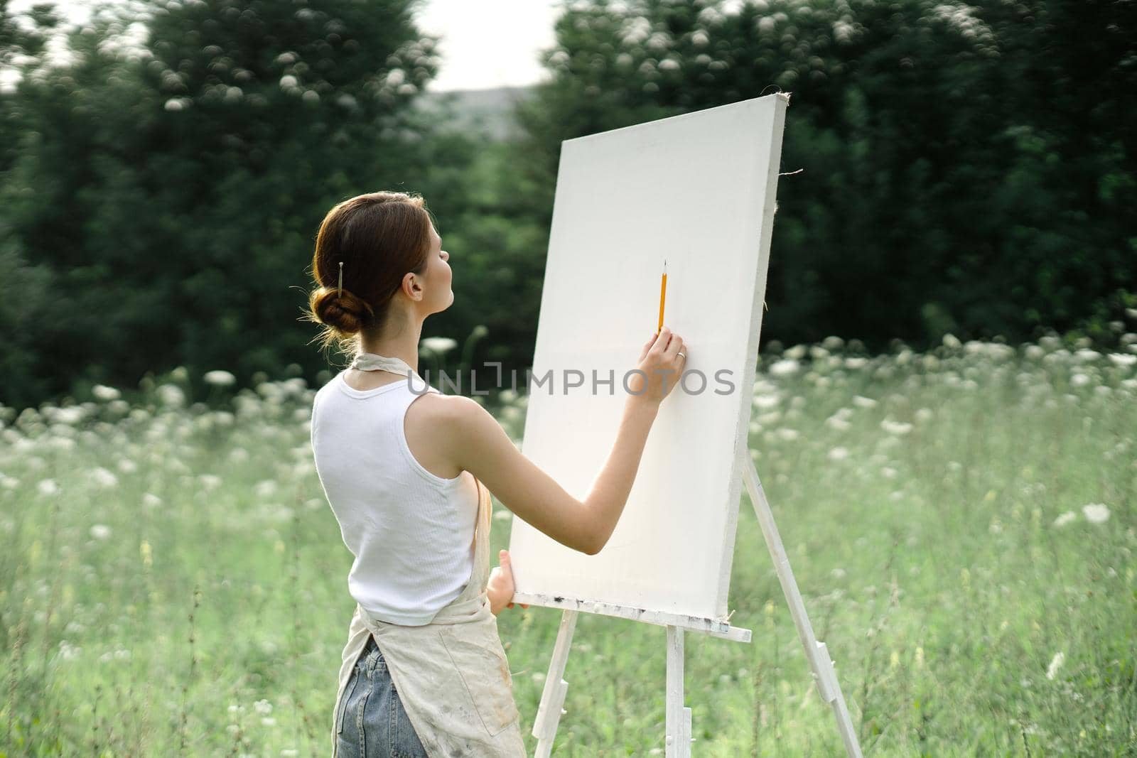 woman outdoors painting a picture creative art landscape. High quality photo