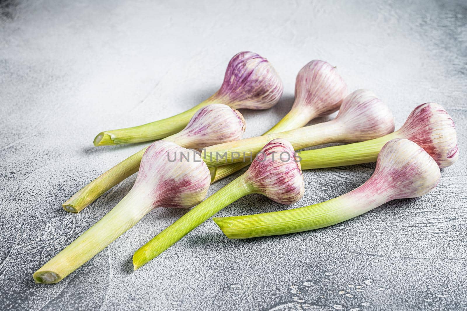 Spring young garlic bulbs on kitchen table. White background. Top view by Composter