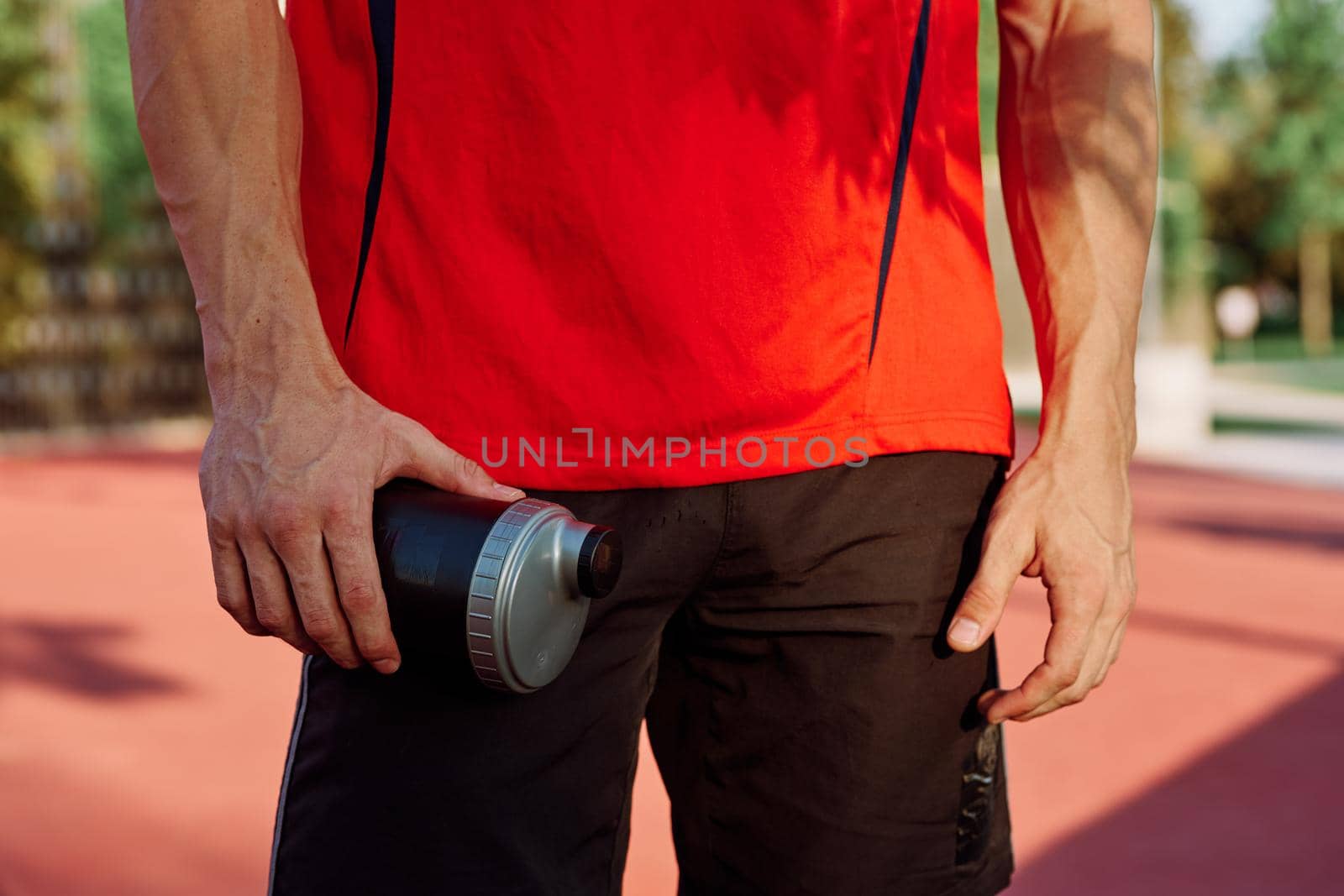 sporty man resting in the park on a bench having a snack. High quality photo