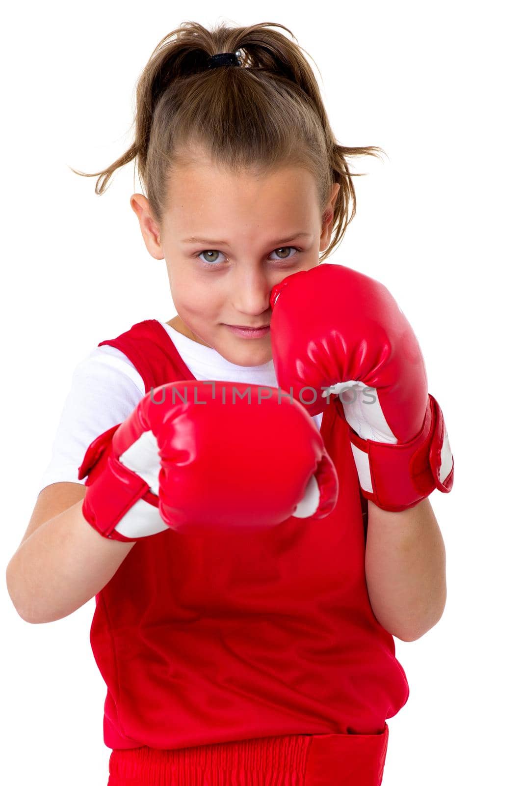 Sports boxer teenage girl. Close up portrait of beautiful girl in red sports uniform and boxing gloves doing boxing exercises. Teenager child posing in studio on white background