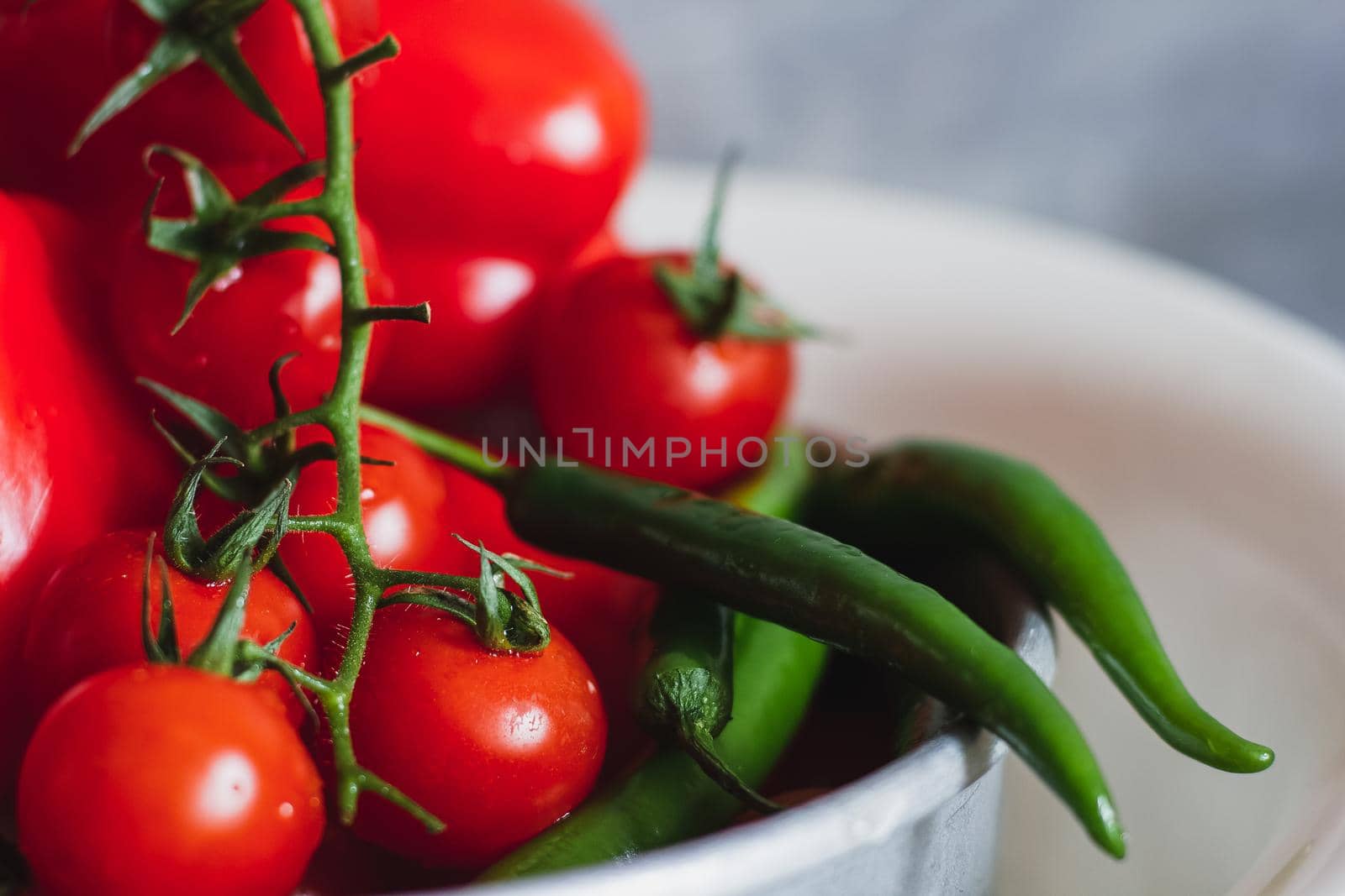Juicy bright mature cherry tomato close-up large long peppers hot chili pepper green red