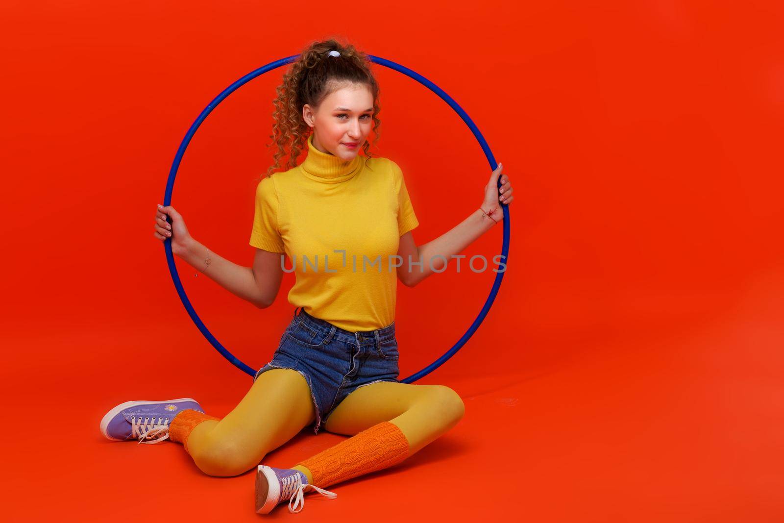 Shot of pretty fitness girl holding hula hoop by kolesnikov_studio