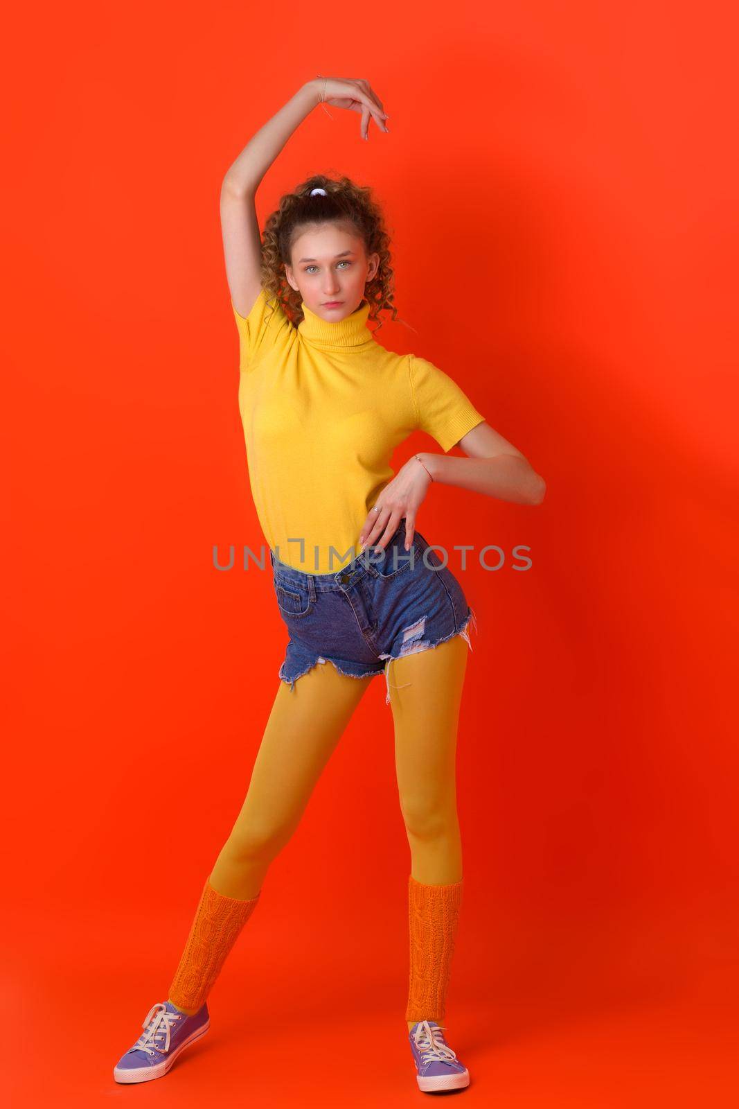 Pretty fitness girl posing relaxed on red backdrop by kolesnikov_studio